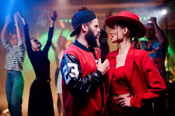 Party and celebration. Happy smiling friends having fun together, singing karaoke in the nightclub.