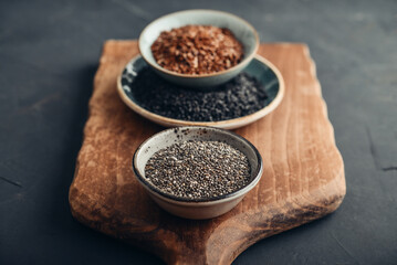 Black sesame, flax and chia seeds in ceramic plates