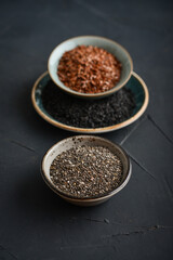 Black sesame, flax and chia seeds in ceramic plates
