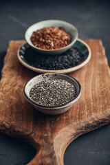 Black sesame, flax and chia seeds in ceramic plates