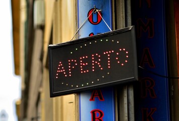 Brightly lit sign on the side of a building with the words 'Aper' displayed in large, bold lettering