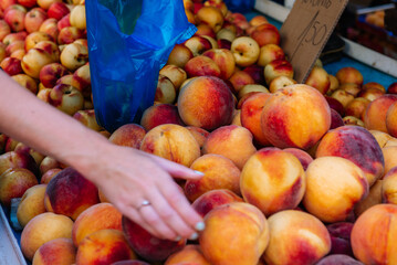fresh peaches in the hand on the farmers market.