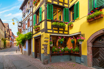 One of the many picturesque and colorful streets and alleys of shops in the medieval village of Ribeauville, in the Alsace wine region of Northeast France.