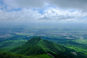 View of the green slopes of the mountains, the valley and the blue sky in the clouds