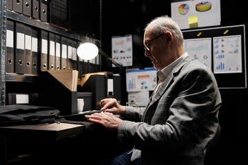 Accountant businessman employee unpacking laptop in office suitcase bag starting shiftwork. Senior...