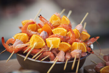 Cooking Salmon and shrimps skewers with oranges. Delicious Barbecue salmon skewers. Raw seafood on skewers. Outdoor cooking, barbecue, gastronomy, seafood, cookery, street food concept. ready to cook