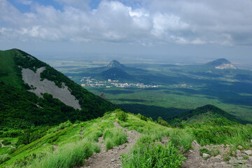 View of the green slopes of the mountains, the valley and the blue sky in the clouds