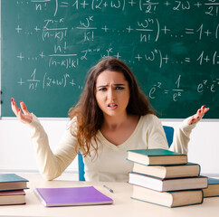 Young female math teacher in front of chalkboard