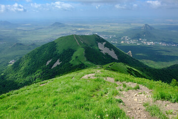 Dirt path hiking trail climbs through Caucasus mountains with view on a valley