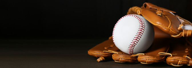 Leather baseball glove with ball on wooden table, space for text. Banner design