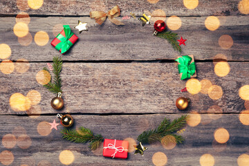 Beautiful Christmas frame with festive decorations and space for text on wooden table, flat lay. Bokeh effect