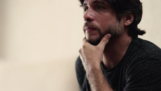 Preoccupied young man with pensive expression. Stressed worried male person in 30s closeup face