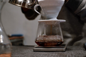 Barista brewing V60 coffee in a server glass
