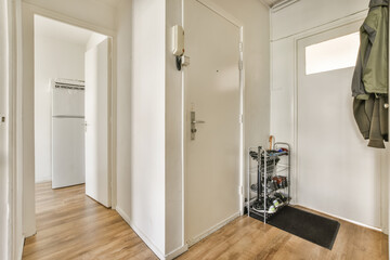 the inside of a room with wood floors and white walls, there is an open door that leads to another...