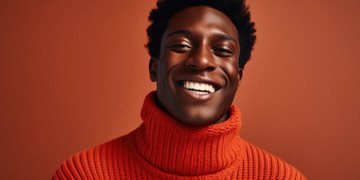 Handsome black man, wearing polo neck orangey red sweater 