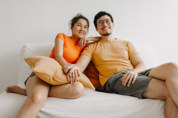Lovely romantic asian couple watching tv movie together happy vibes weekends.