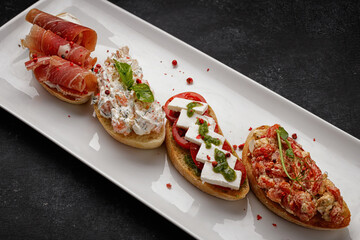 Various Bruschettas with ham, seafood, vegetables and cheese