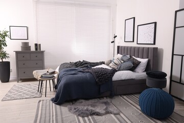 Large comfortable bed with soft pillows and blankets in room. Home textile
