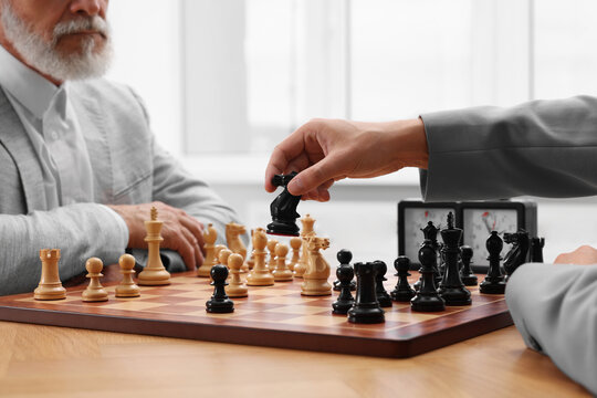 Men playing chess during tournament at table, closeup