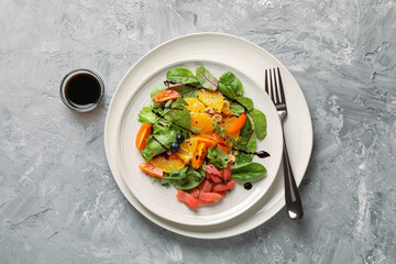 Delicious salad with salmon served on gray textured table, flat lay