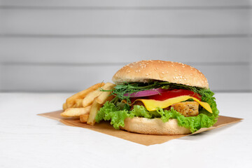 Delicious burger with tofu and fresh vegetables on white table, space for text