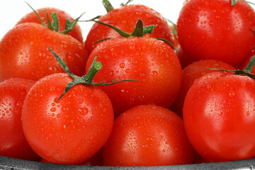 Many fresh ripe cherry tomatoes with water drops on white background, closeup