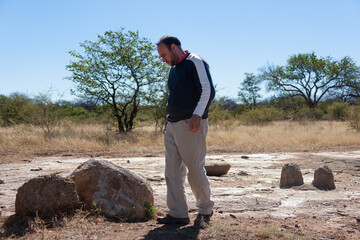 Egyptian arabic man archeologist, geologist studying rocks near a artifact burial site
