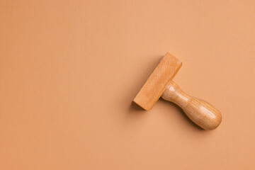 One wooden stamp tool on light brown background, top view. Space for text