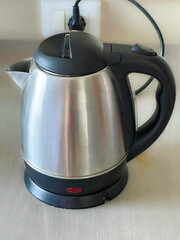 silver jug tea pot on electrical kettle with black handle 