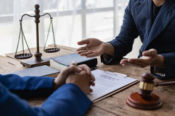 Lawyers discuss contracts or business deals at a law firm. justice service concept Close-up of hammer and scale sitting next to each other.