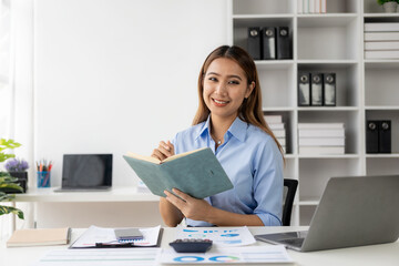 Cheerful businesswoman working with laptop, female office worker smiling charmingly. Work with financial documents to analyze company financial data.
