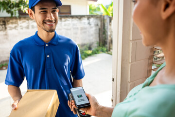 Asian young delivery man delivering package to woman customer at home.  - obrazy, fototapety, plakaty