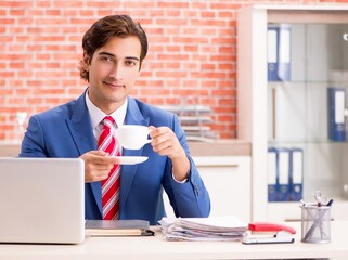 Young handsome employee working in the office