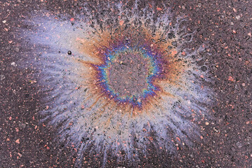 A fuel or oil stain on wet asphalt on a rainy day