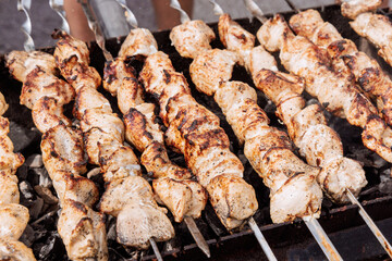 Traditional Turkish kebab cooked outdoors on skewers over hot grill with burning fire
