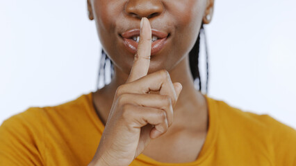 Secret, finger to lips and black woman in studio for privacy, confidential information and face on...