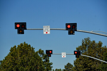 Blinking Stop lights above crosswalk on busy street