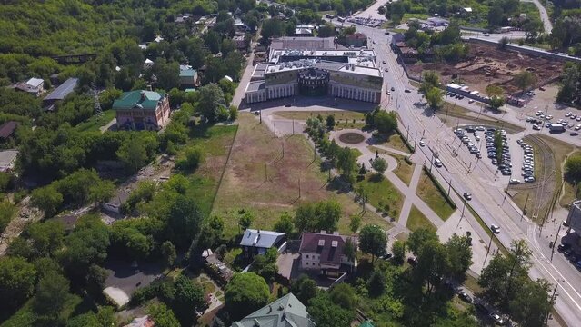 Aerial view of a summer green city, sleeping area. Clip. Ordinary houses and streets with park zones.