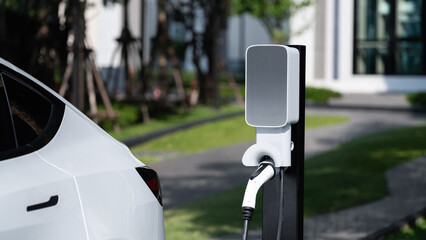 EV electric car charging in green sustainable city outdoor garden in summer. Urban sustainability...
