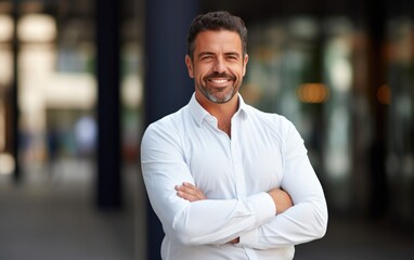 Businessman is standing with his arms crossed, wearing a crisp white shirt