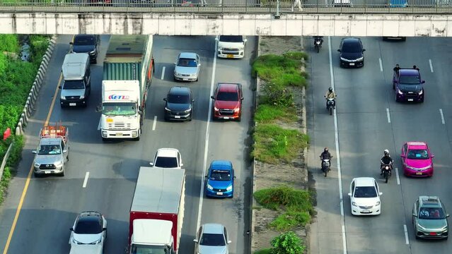 From high above, a drone captures the motorway's congestion, resembling a sprawling maze of stalled vehicles, each a pixel in the intricate mosaic of rush hour gridlock. Traffic jam background.
