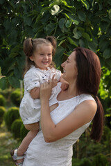 Happy mother with her cute daughter spending time together in park