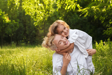 Obraz premium Beautiful mother with her cute daughter spending time together outdoors. Space for text