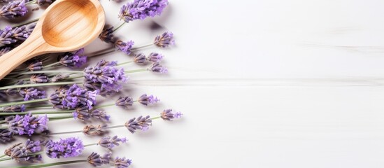 Obraz na płótnie Canvas A lavender flower arrangement along with a wooden plate spoon soap and branches is placed on a white background The image is toned and suggests a spa concept The view is from above close up