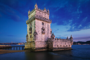 Belem Tower or Tower of St Vincent - famous tourist landmark of Lisboa and tourism attraction - on the bank of the Tagus River (Tejo) after sunset in dusk twilight with dramatic sky. Lisbon, Portugal