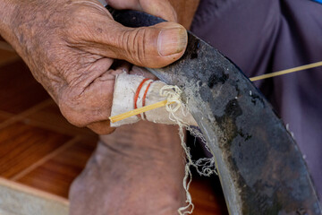 Obraz premium A carpenter sharpens bamboo to use in crafts.