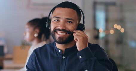 Portrait, smile and man at call center on headphones for crm support on bokeh at night. Face, happy sales agent on mic and telemarketing consultant, customer service professional or worker in office - Powered by Adobe