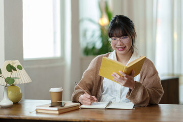 Asian female office worker uses her thoughts and ideas to read a book in a relaxed manner. and take...