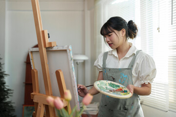 Young female student studying in the art studio Learn how to draw landscapes Mixing watercolors to...