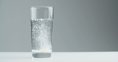 Vitamin effervescent tablet dissolves in a glass of water